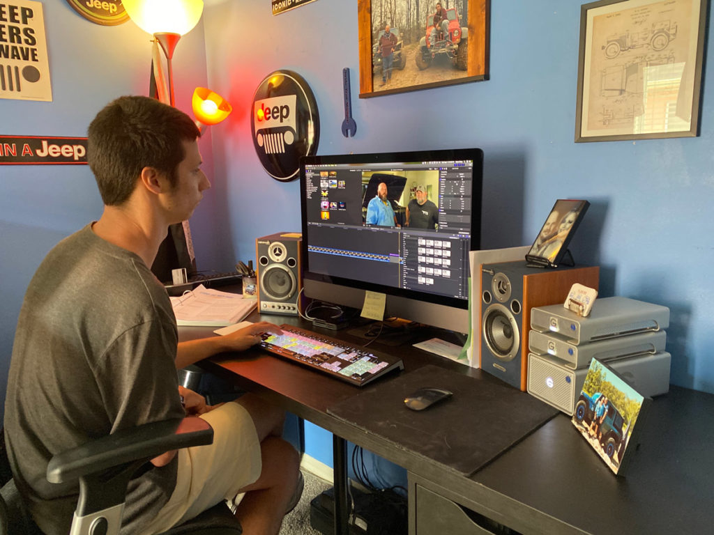 videographer editing on computer at desk
