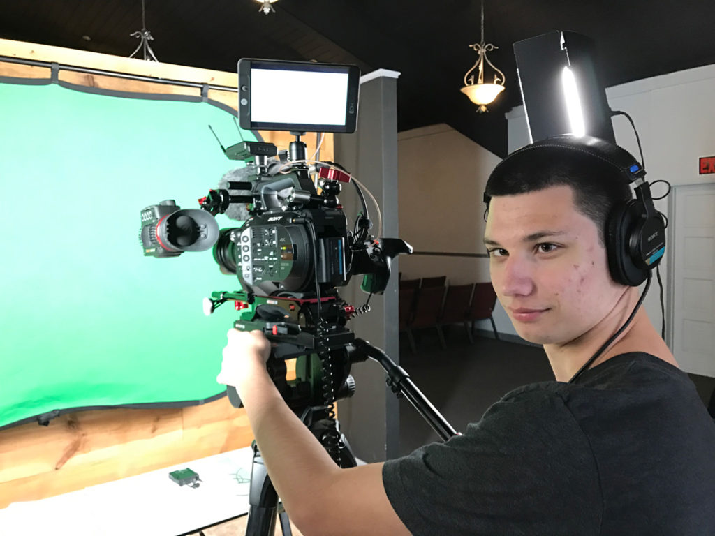 Videographer filming a green screen