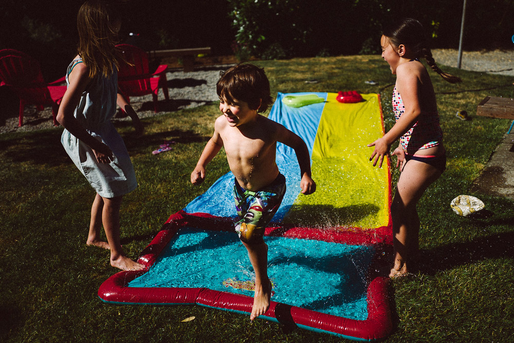Kids playing outdoors on a water slide