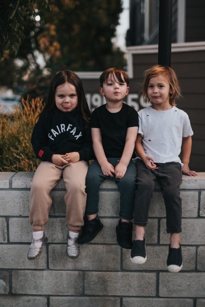 three-kids-sitting-wall