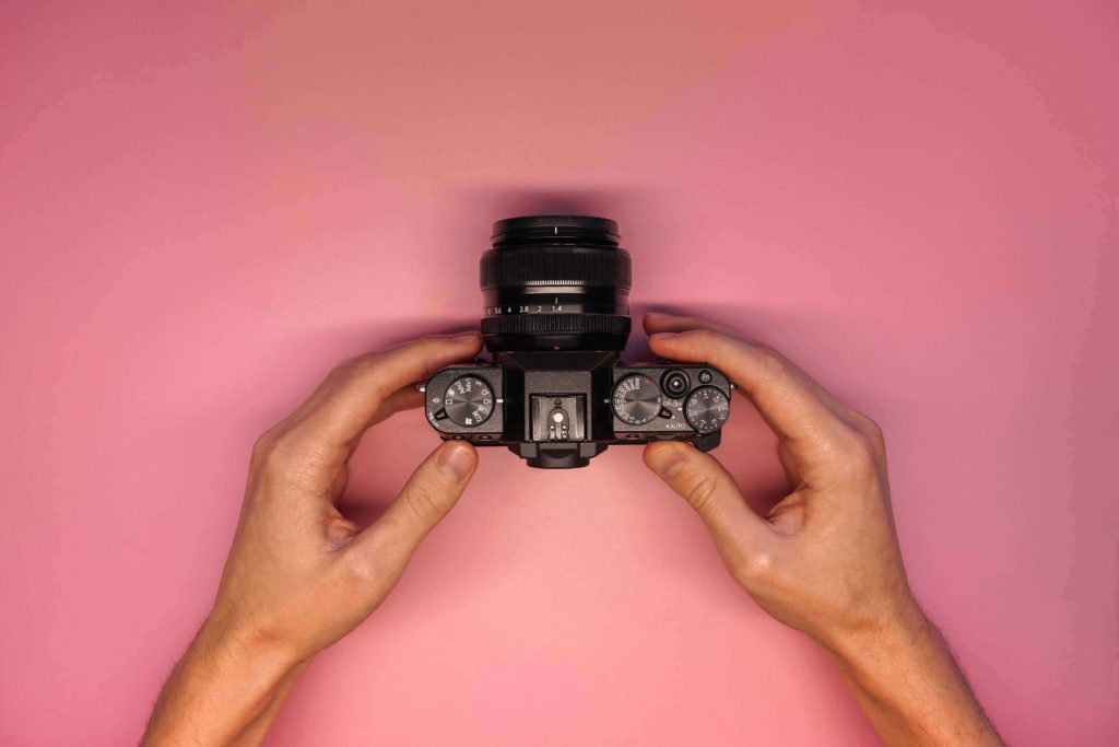 hands-holding-mirrorless-camera